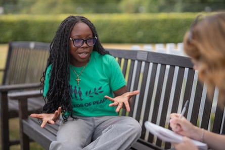 Esther sat on bench speaking with someone