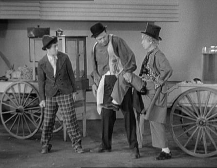 A still from the 1933 film Duck Soup, where Chico and Harpo place their legs into a lemonade stand owner's hands