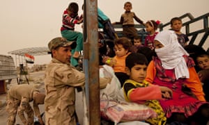 Iraqi soldiers search a convoy of families fleeing Isis-held Hit at a checkpoint at Ramadi.