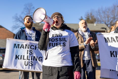 people wear shirts that say "end fossil fuels" and hold signs that say "Manchin is killing us"