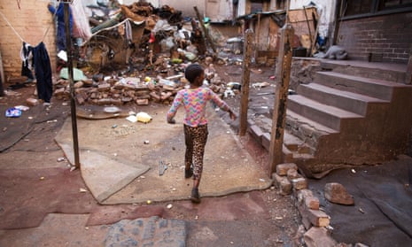A child plays outside the burned-out 54 Soper Road in Johannesburg, where 100 people still live.