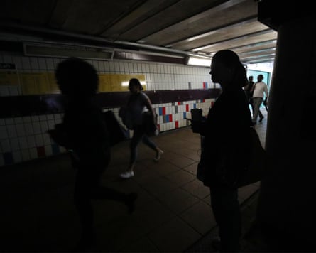 People walking in complete darkness at Clapham Junction station in London during a power cut