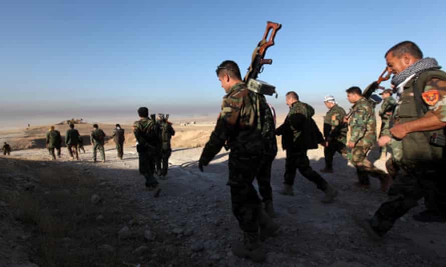 Peshmerga forces walk in the east of Mosul during operation to liberate the city from Isis.