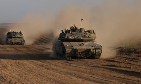 Um soldado israelense gesticula do topo de um veículo do exército perto da cerca da fronteira israelense com a Faixa de Gaza.