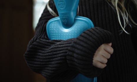 A model in a thick jumper holds a hot water bottle.