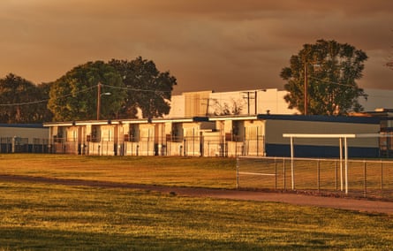 Mobile classrooms sit against a warehouse backdrop in Bloomington, in reddish light