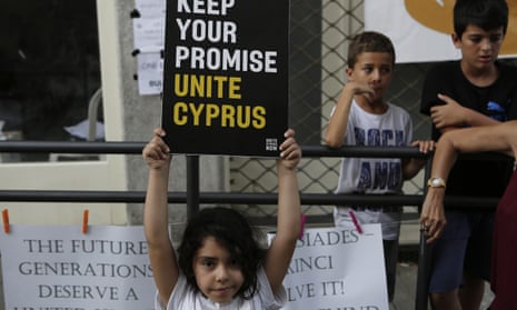 A girl holds up a board during a protest at a crossing point inside the UN buffer zone in Nicosia, Cyprus.
