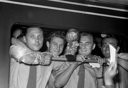 West Germany players – from left: Max Morlock, Hans Schaefer, Jupp Posipal, and Hans Bauer – hold the World Cup trophy during a stop of the train in Singen, Germany a day after the final.
