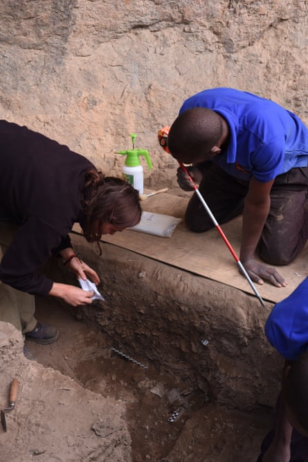 Researchers with equipment in near a stone excavation