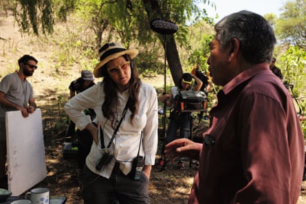 Lucrecia Martel talking to crew in a green landscape