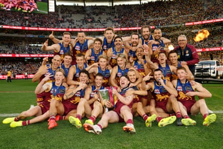 The Lions pose for a photo with the premiership cup at the MCG after the grand final
