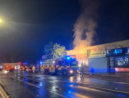 Fire engines and smoke on a street in Belfast where shops were set alight