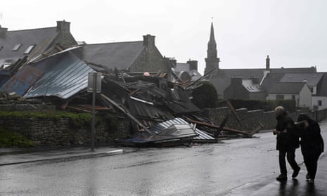 Pedestrians walk past a destroyed warehouse in Porspoder, western France.
