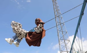 A young girl on a swing under a blue sky