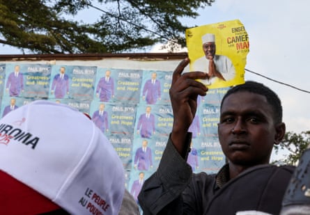 A person holds a leaflet with presidential opposition candidate Issa Tchiroma Bakary picture