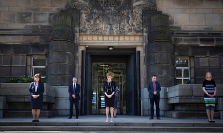 Scotland’s first minister, Nicola Sturgeon, observes the minute’s silence outside St Andrew’s House in Edinburgh