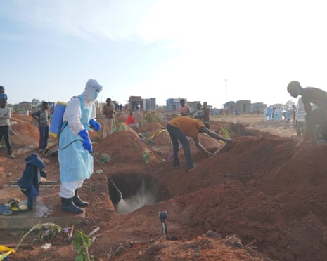 A health worker sprays disinfectant in a freshly dug grave of someone who died of Ebola, in Bunia, Democratic Republic of the Congo
