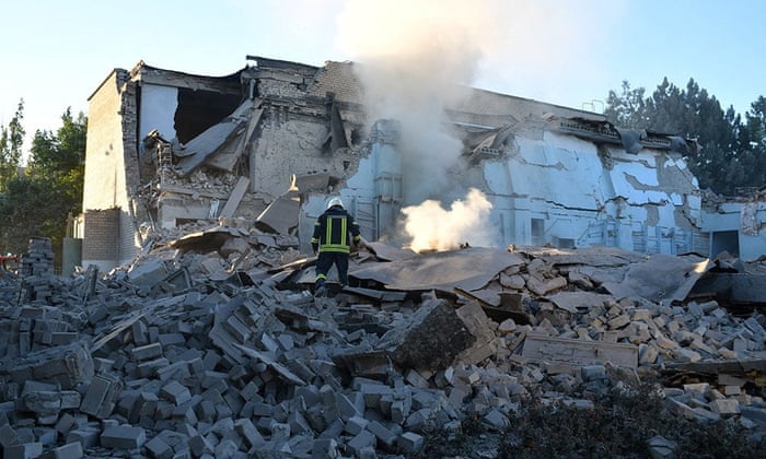 A firefighter works at a site of a school building destroyed by a Russian military strike in Mykolaiv, 14 July.