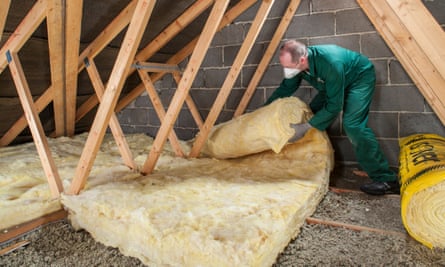 A man installing insulation in a loft.