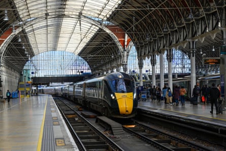 A GWR intercity express train arrives at Paddington station in London, under the arched roof.