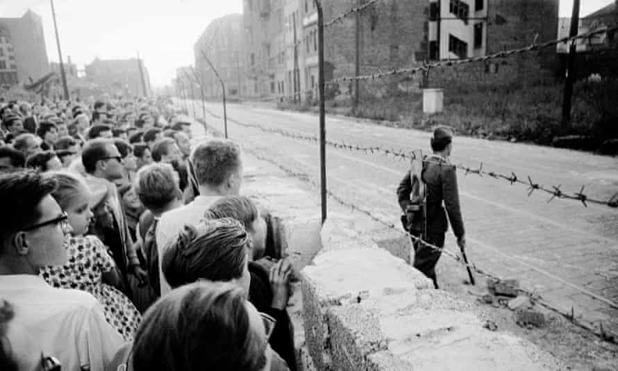 West Berliners watch an East German soldier on patrol on the other side of the Berlin Wall in 1961.
