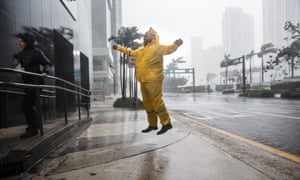 Weather reporters jump to illustrate the force of the winds caused by Hurricane Irma as it arrives in Miami.