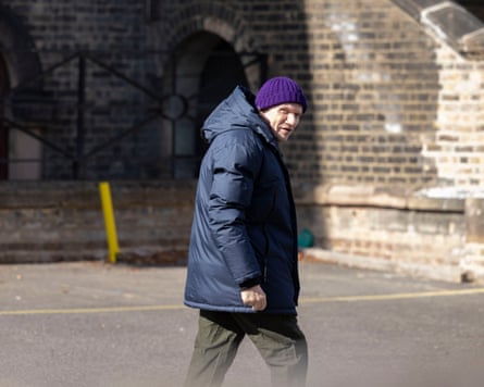 A man looks at the camera as he walks away