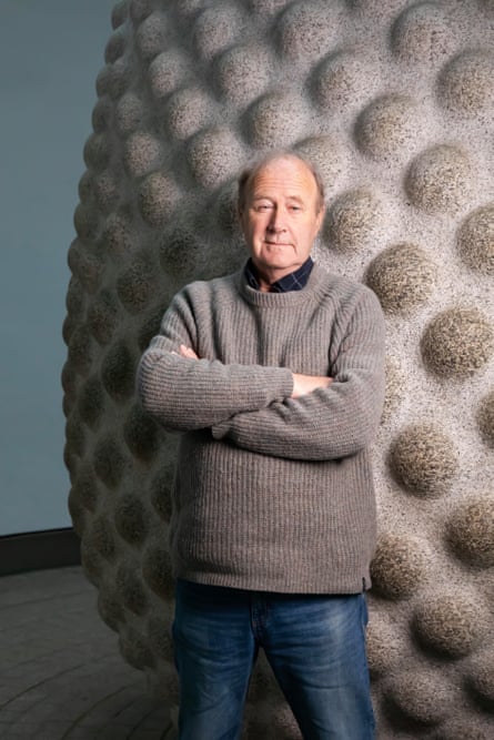 Tim Smit posing for a photo in front of a giant seed sculpture