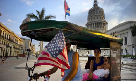 A taxi pedals his bicycle, decorated with Cuban and US flags near El Capitolio in Havana, Cuba, on Tuesday. Barack Obama will travel there on Sunday.