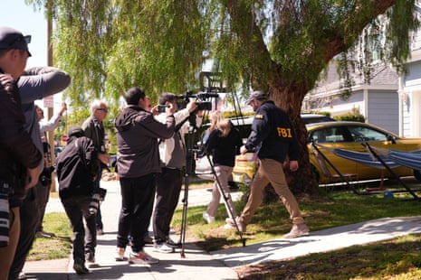 एफबीआई एजेंट और पत्रकार घरों के बाहर फुटपाथ पर खड़े हैं