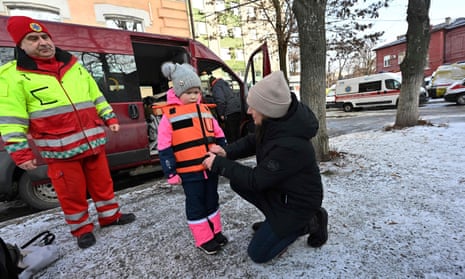 Volunteers try a children's bulletproof vest on Zlata, a six-year-old Ukrainian girl in Kharkiv.