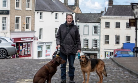 Ian McCullum standing in the street with two dogs