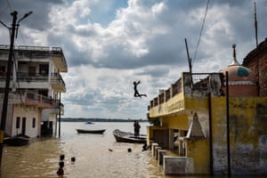 Allahabad, India: a child jumps into the water after rising levels in the rivers caused flooding in the Jhusi area