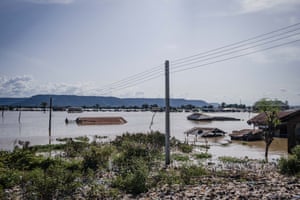 Flooded land, with electricity poles surrounded by water.