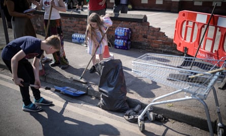 Children who live nearby helping to sweep up the street outside the mosque.