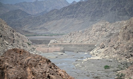 A damaged dam surrounded by barren mountains