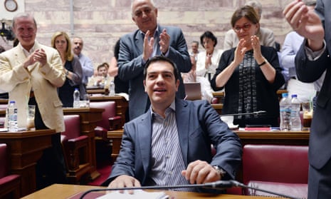 Greek prime minister Alexis Tsipras is applauded by lawmakers before addressing his parliamentary group meeting in Athens.