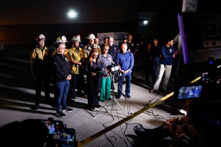 a group of people stand at microphones during a press conference