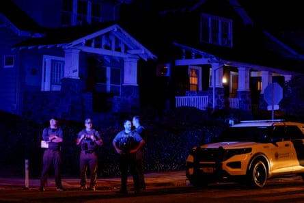 four men in uniform on street at night