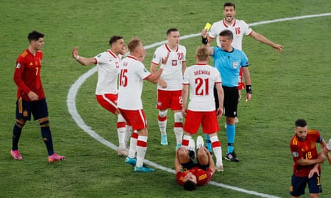 Poland’s Kamil Jozwiak is shown a yellow card by referee Daniele Orsato.