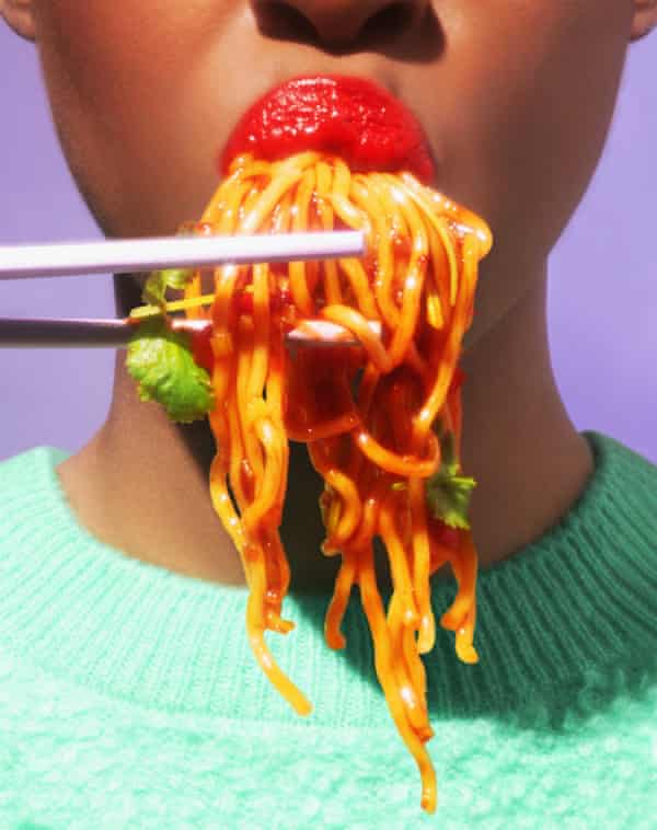 Chopsticks are lifting noodles that are being eating by reddish lips
