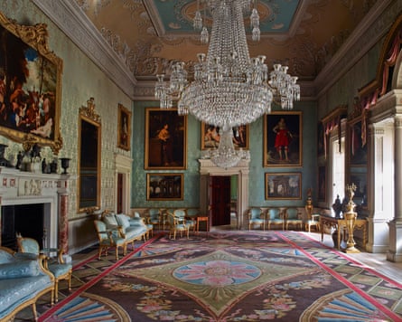 The ornate saloon at Saltram, with paintings hanging on wall and a crystal chandelier from the ceiling.