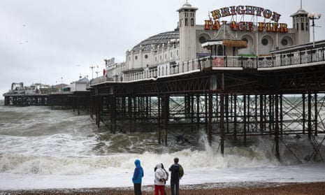 People look at the waves near the Palace Pier in Brighton on 5 August, as Storm Antoni brings rain and high winds to the UK. 