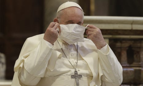 Pope Francis puts on a face mask as he attends a ceremony in the Basilica of Santa Maria in Aracoeli, in Rome