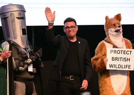 Andy Burnham waves at the Makerfield byelection count, flanked by Count Binface and a