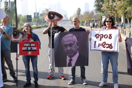 A demonstrator holds up a placard depicting Israeli prime minister Benjamin Netanyahu as families and supporters of Israeli hostages held by Hamas in Gaza block a main road during a protest calling on the Israeli war cabinet to make a deal for the release of hostages in Tel Aviv.