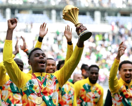 Moussa Niakhaté holds the Africa Cup of Nations aloft as he and his Senegal teammates parade it around the Stade de France in Paris before playing a friendly against France