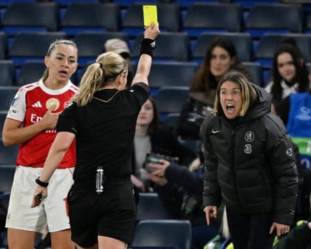Chelsea’s head coach, Sonia Bompastor, shouts at the referee, who is giving her a yellow card, while Arsenal’s Katie McCabe looks on
