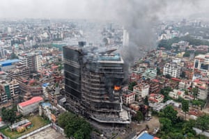 Aerial view of a towering building partly on fire