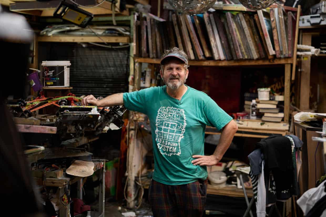 Pete Strong stands with hand on hip in his Tortuga Studios workshop
